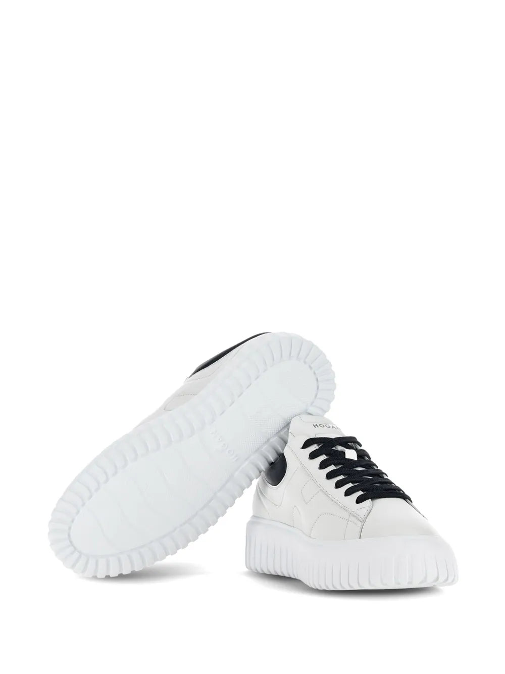 White leather sneakers, side view with black laces and thick ridged outsole