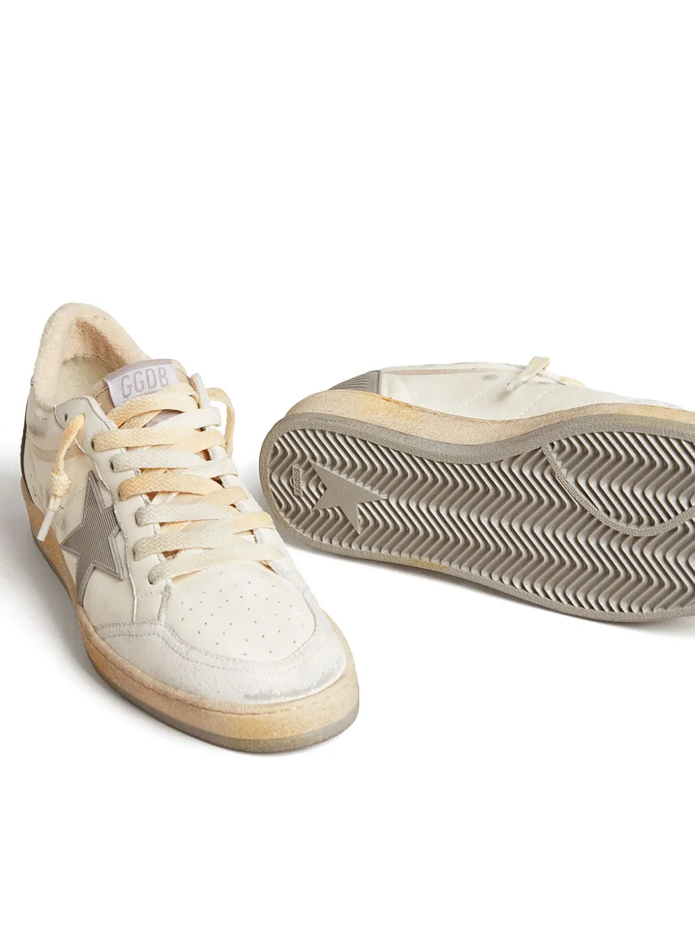 White leather sneakers angled view with gray star, lace-up, textured rubber sole