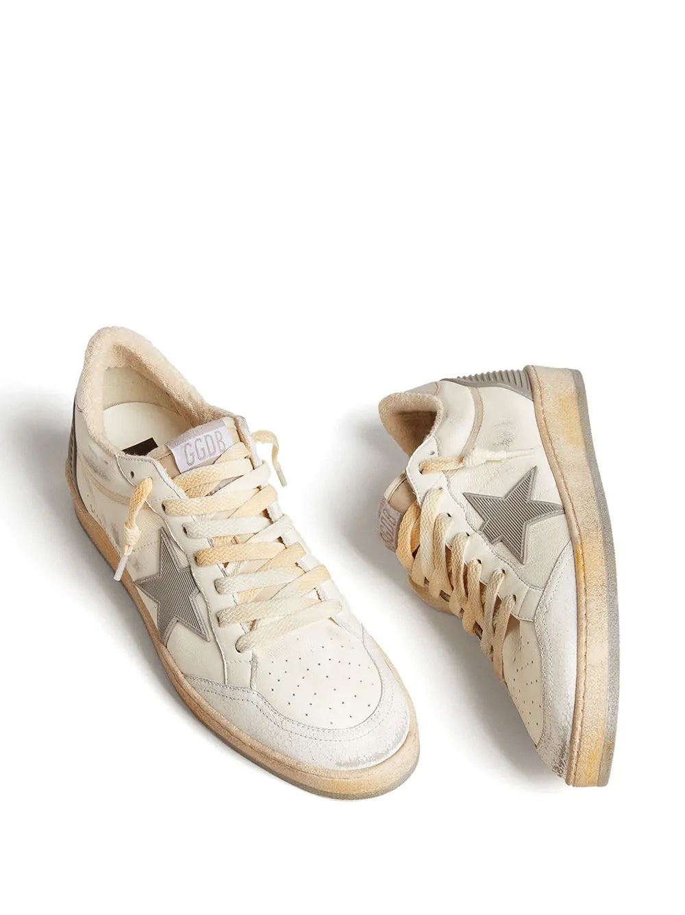 White leather sneakers pair view with gray star patch and lace-up closure