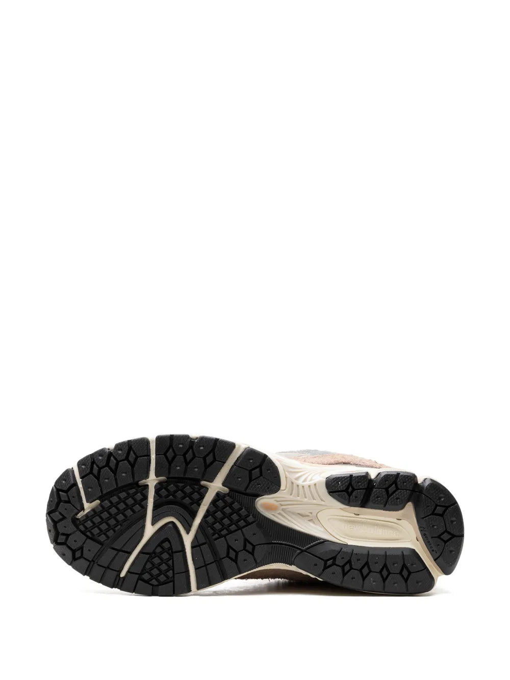 Outsole of beige and black low-top sneakers with textured tread and arch cutouts