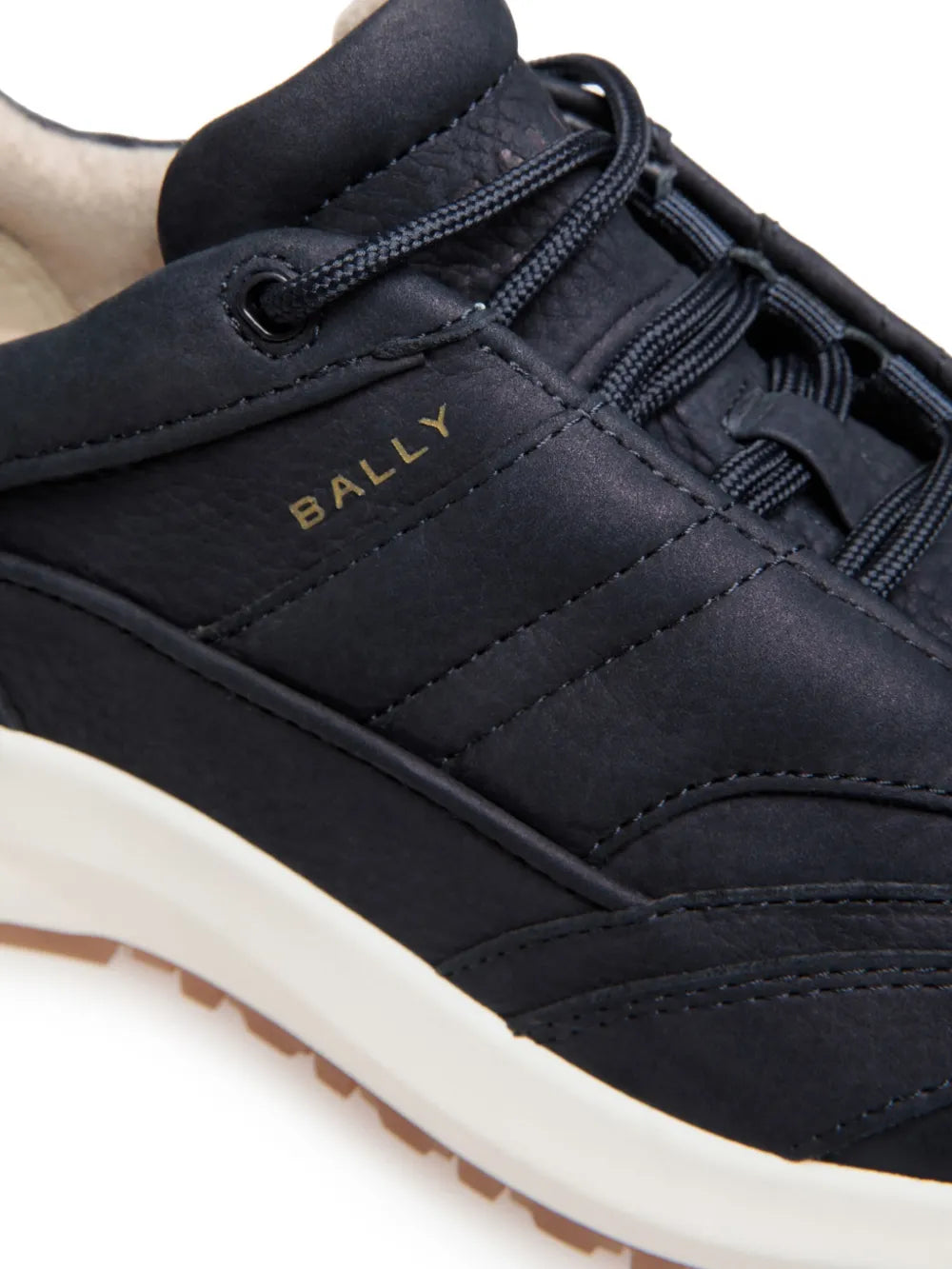 Bally sneaker close-up with embroidered logo, dark navy laces and stitching