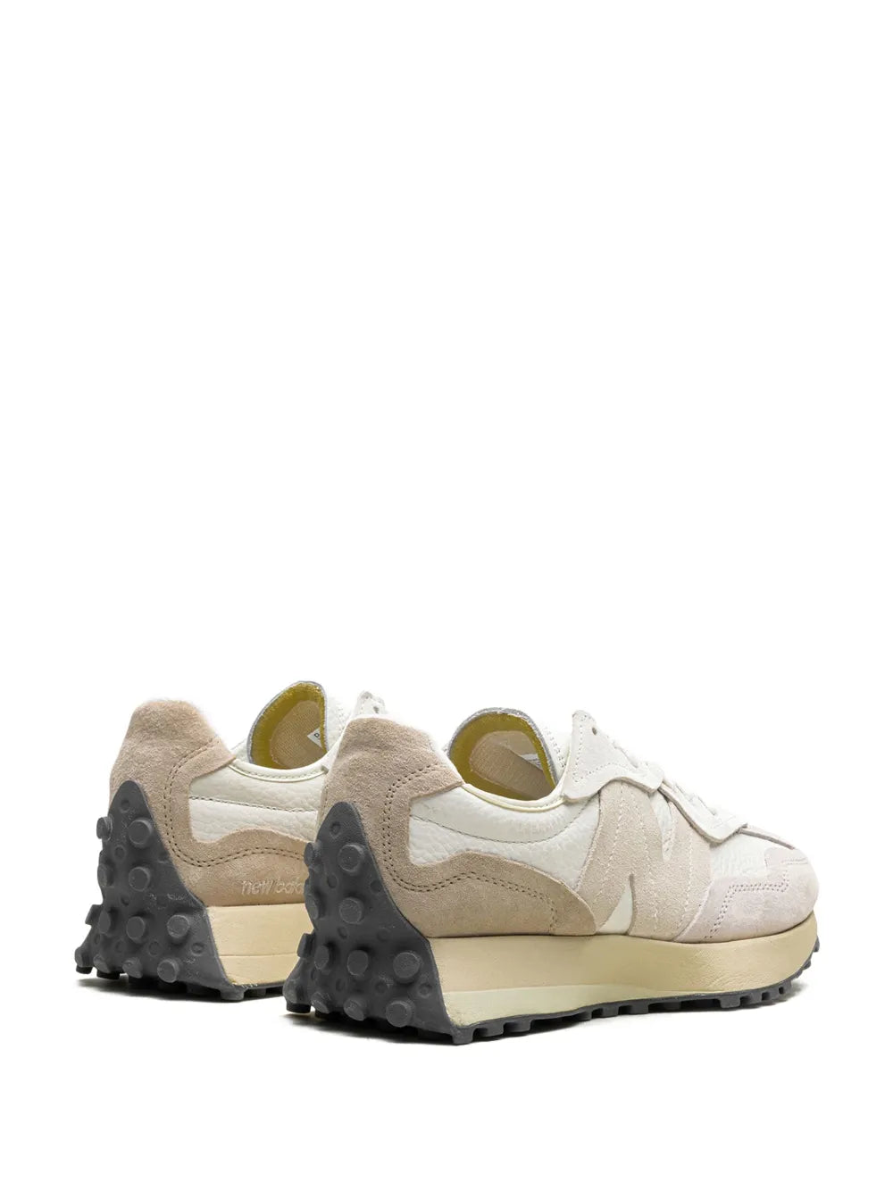 Light grey sneakers with beige heel, black traction pods, and lace-up front