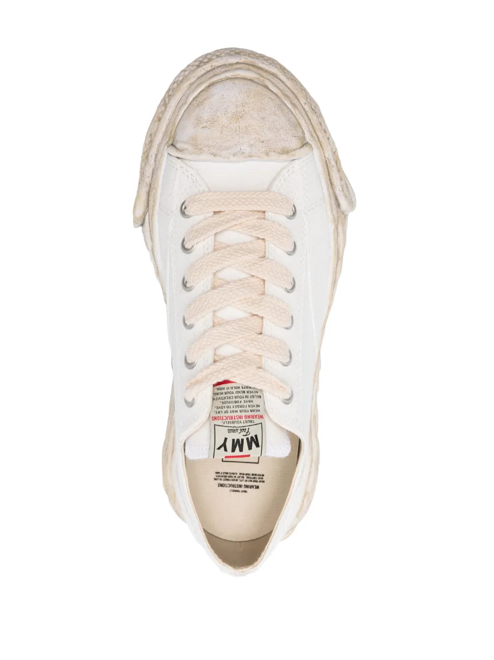 White lace-up sneaker viewed from above, showing laces and stitched toe cap