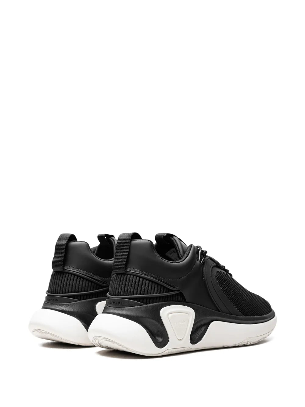 Pair of black chunky lace-up sneakers with ribbed detailing and white sculpted side accents
