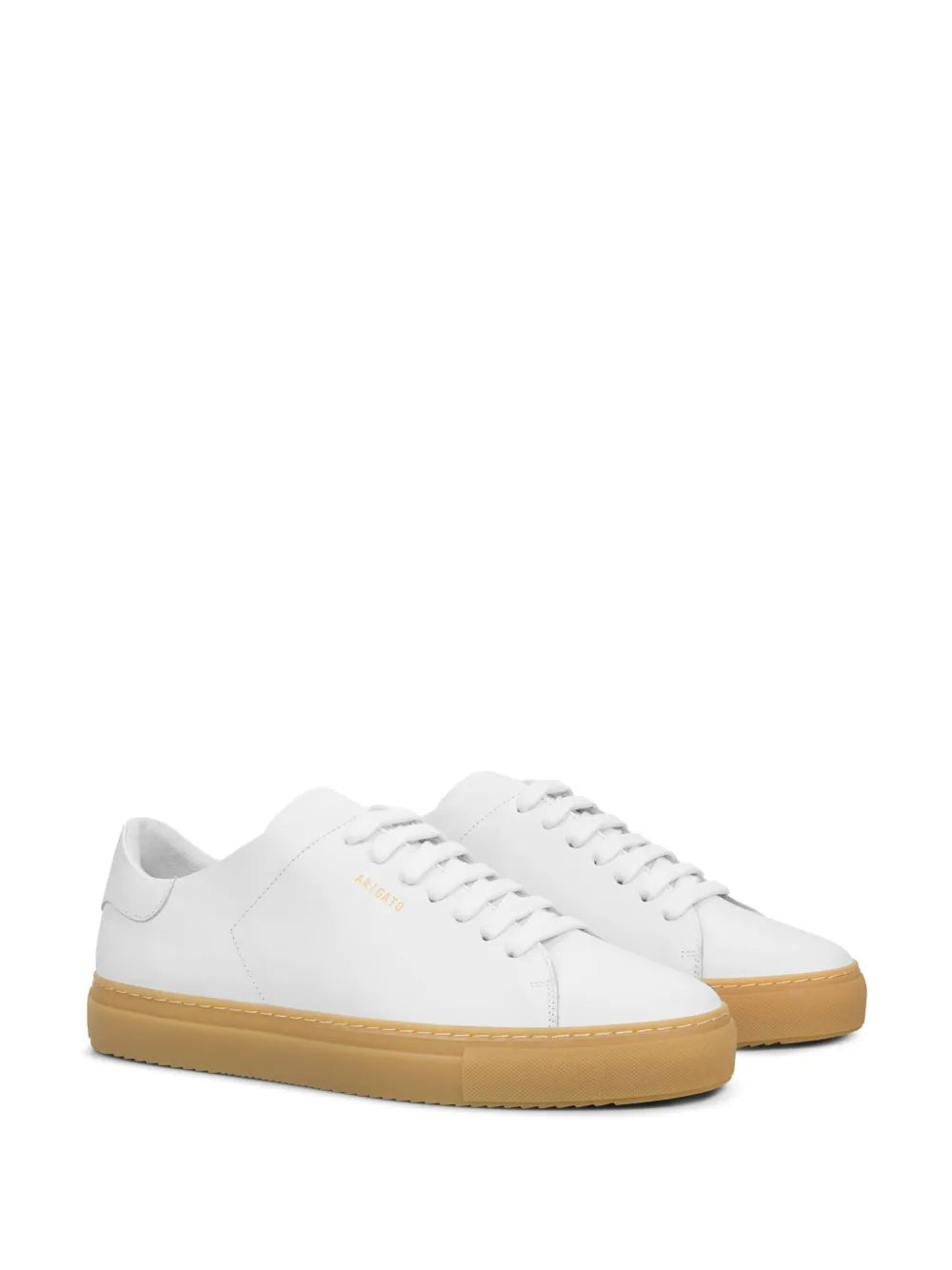 White low-top sneakers with gum-brown outsole, side logo, and lace-up