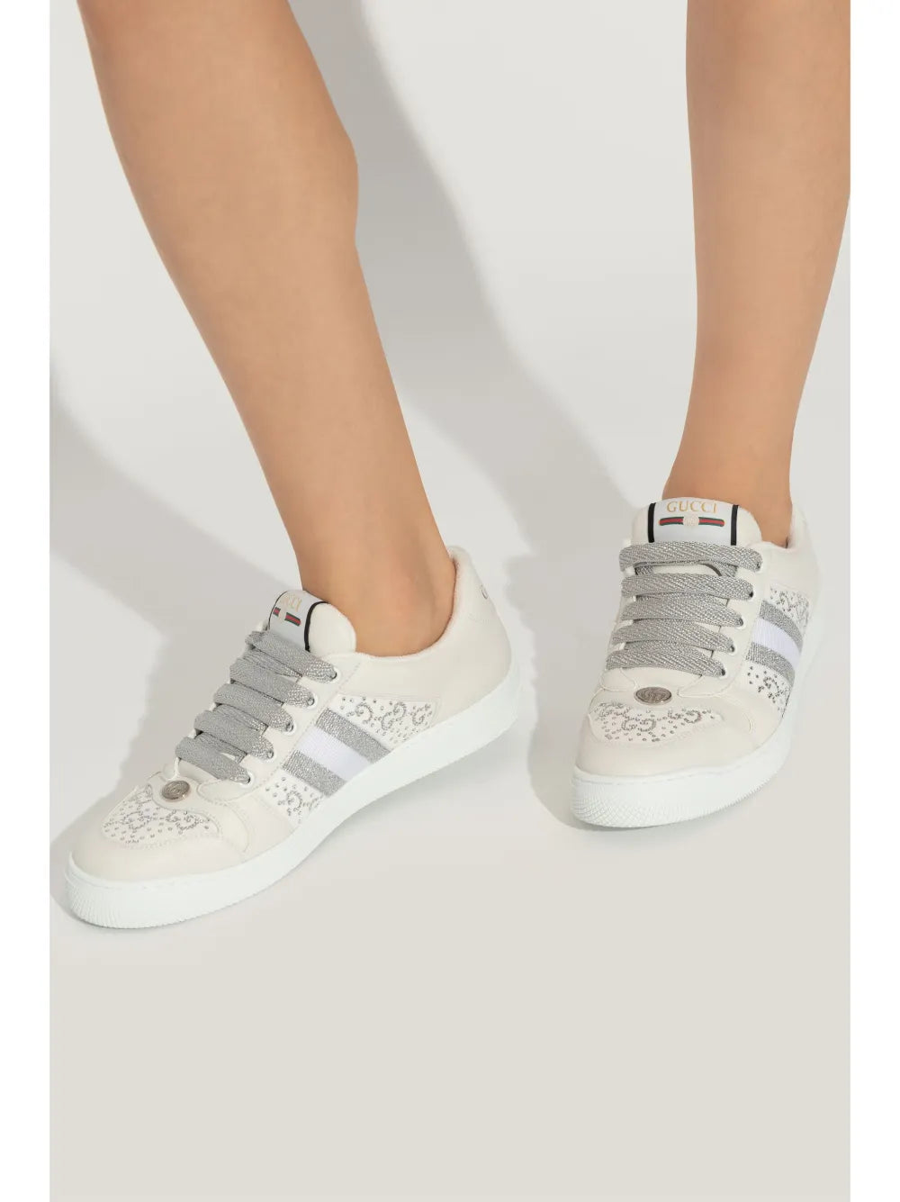 White Gucci Screener sneakers on feet, lace-up with striped panel and textured sole