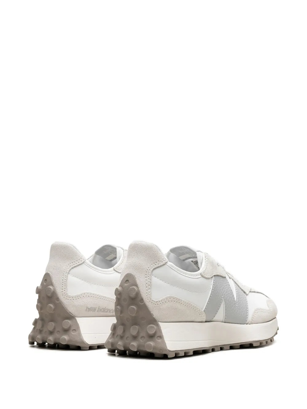 Back view of white New Balance 327 sneaker with cushioned heel and rubber tread.