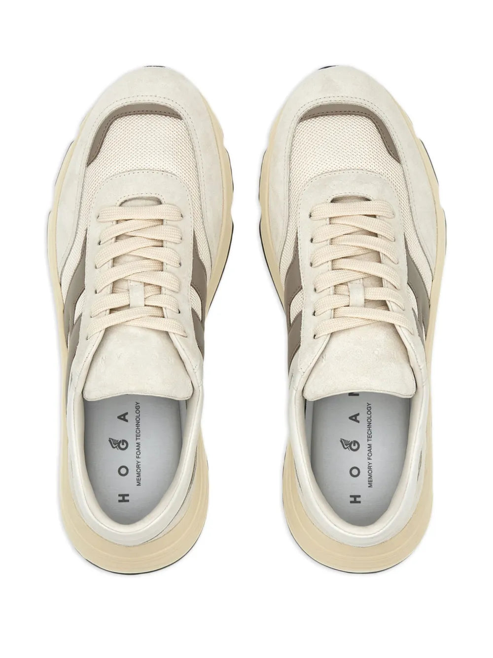 Beige sneakers with white laces and cushioned tongue, front view.