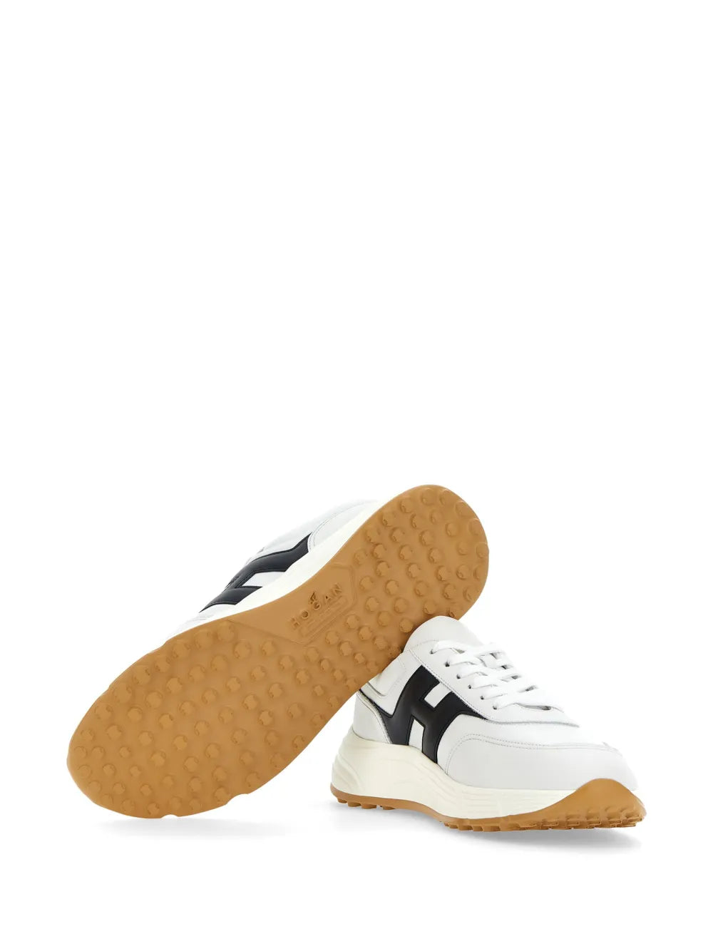 White sneakers with tan rubber outsole tread and black-and-white upper