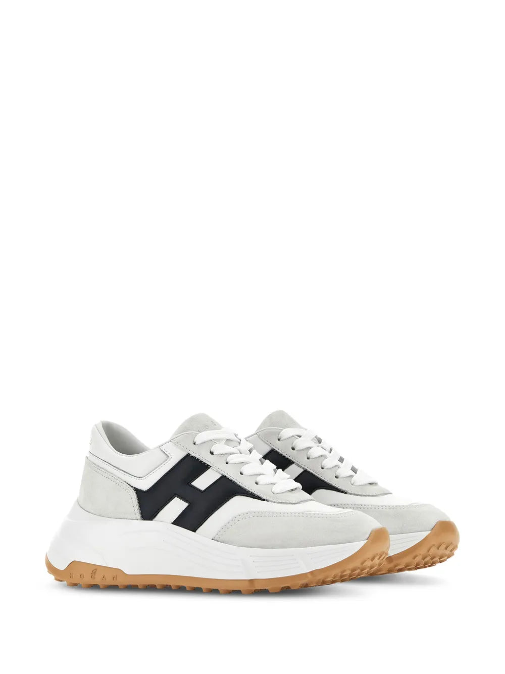 White low-top sneakers with black side logo, white laces, and tan rubber sole