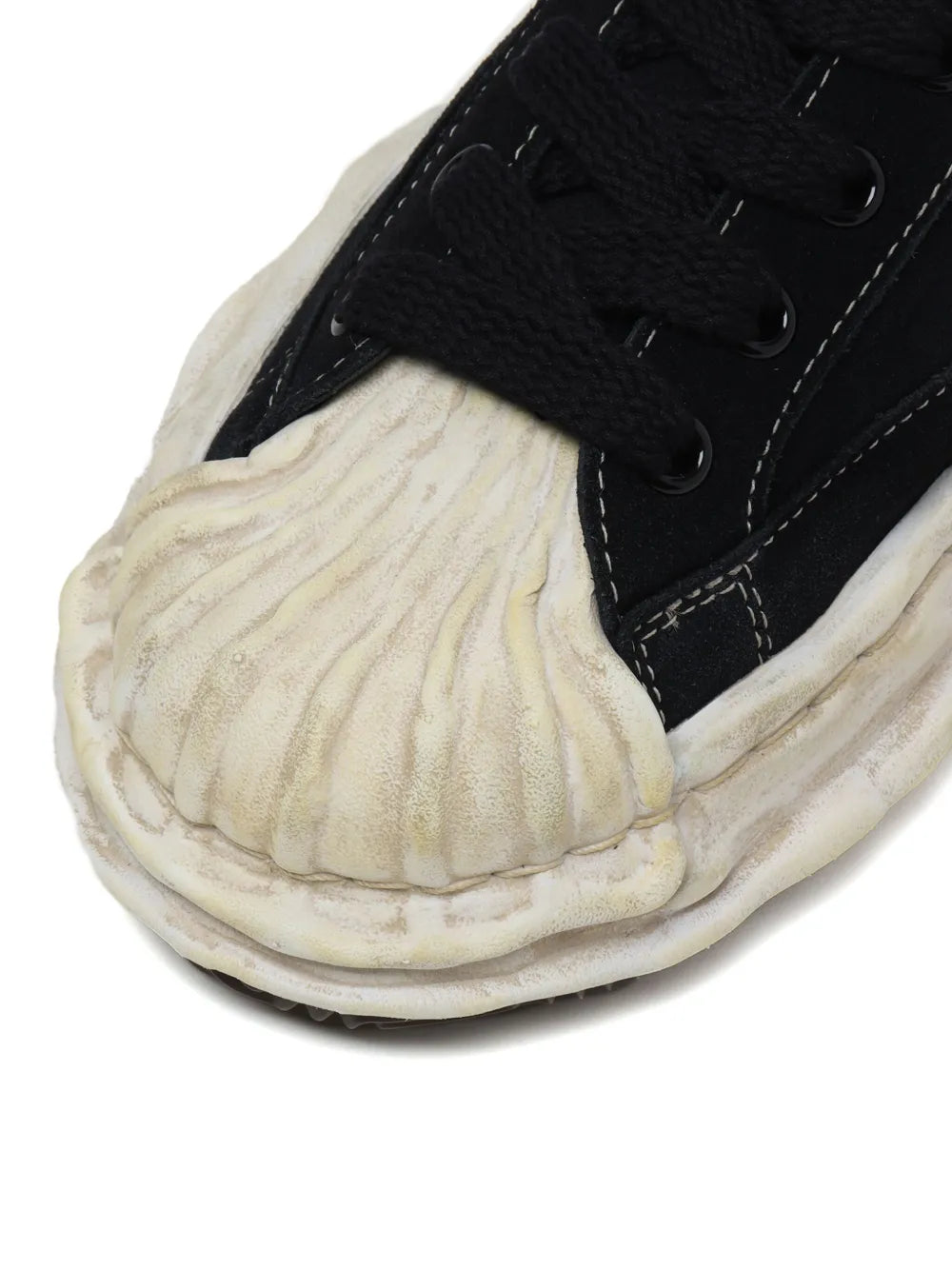 Black lace-up sneaker with distressed off-white sole and textured toe panel