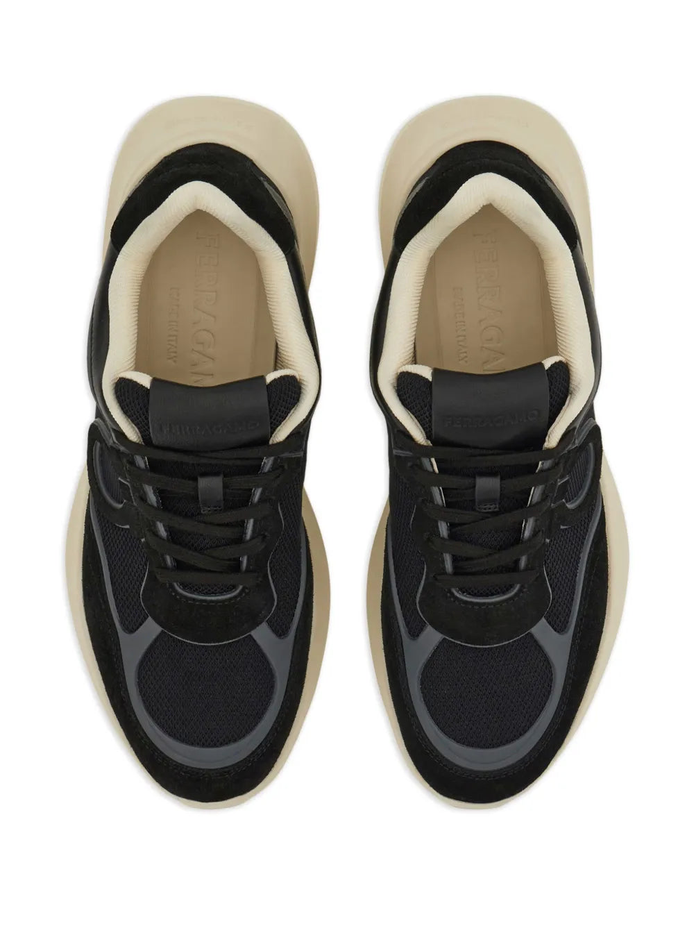 Pair of black lace-up sneakers with cream inner lining and cushioned tongue.