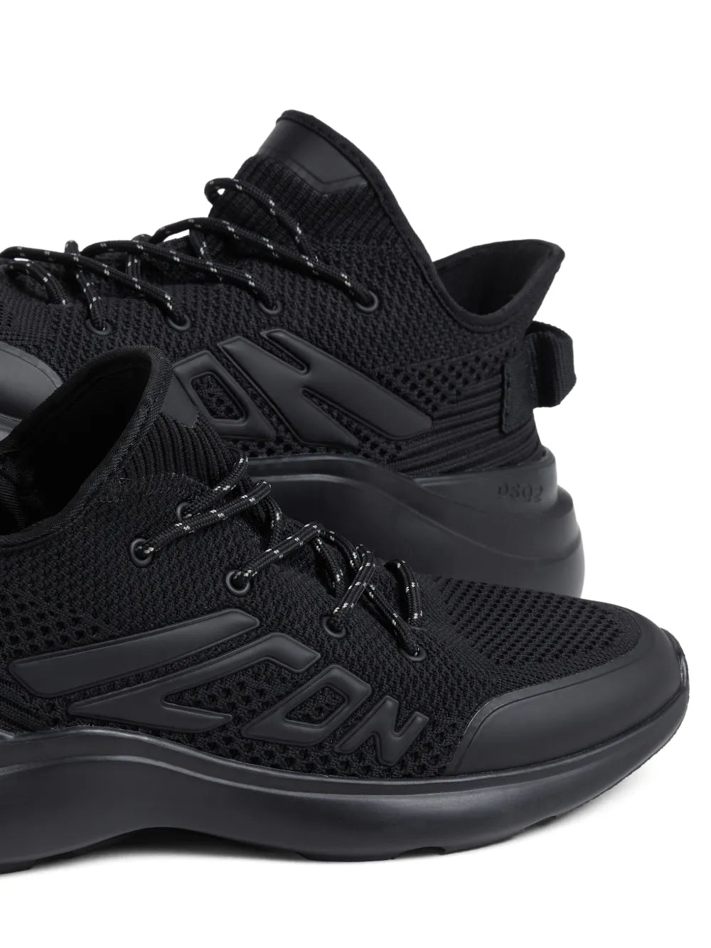 Black Dsquared2 embossed-logo sneakers close-up, lace-up textured upper and chunky sole