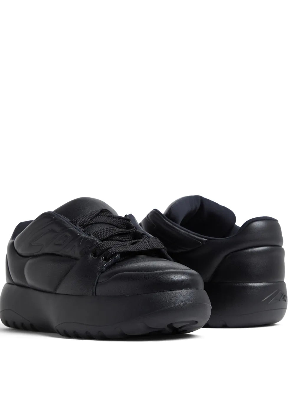 Black leather low-top sneakers with lace-up front, sculpted toe, and logo on side.