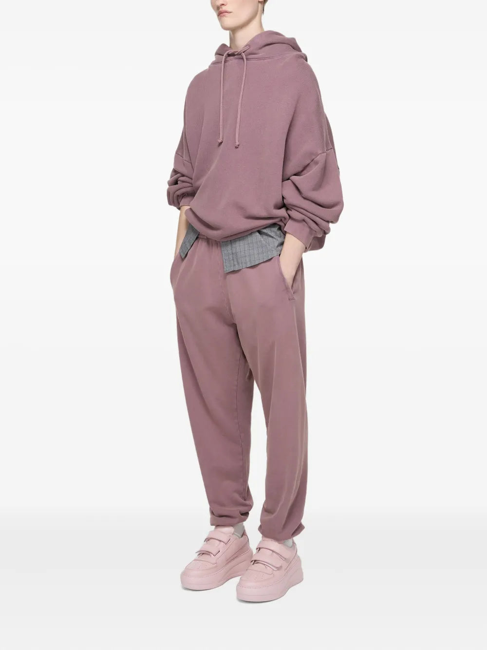 Pink platform sneakers worn with drawstring hoodie and relaxed pants