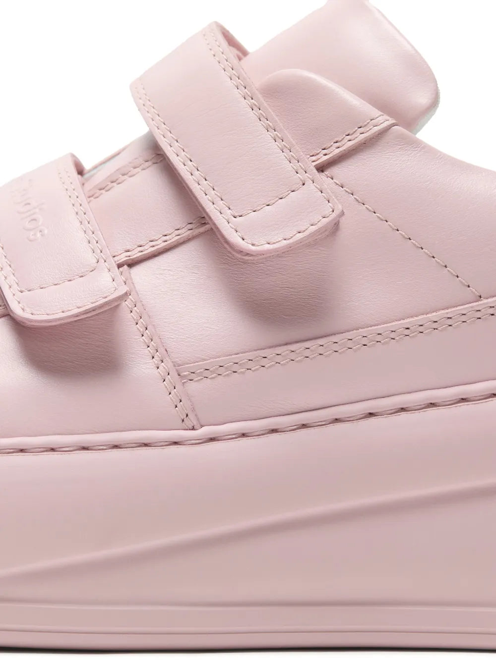 Close-up of pink platform sneaker straps and stitched panel on thick sole