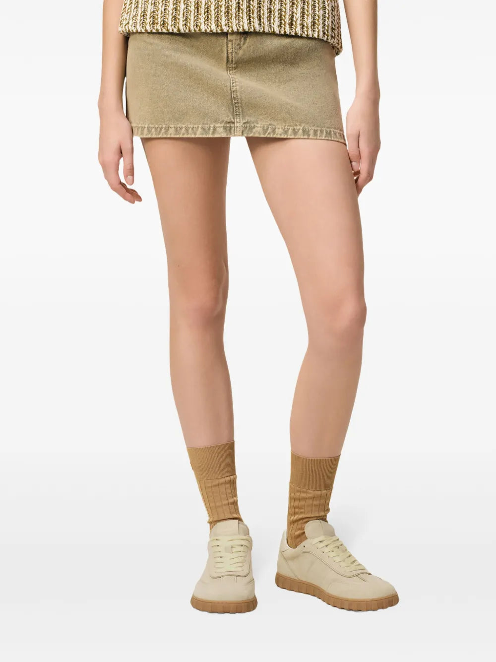Light beige lace-up sneakers worn with light skirt hem, chunky rubber sole