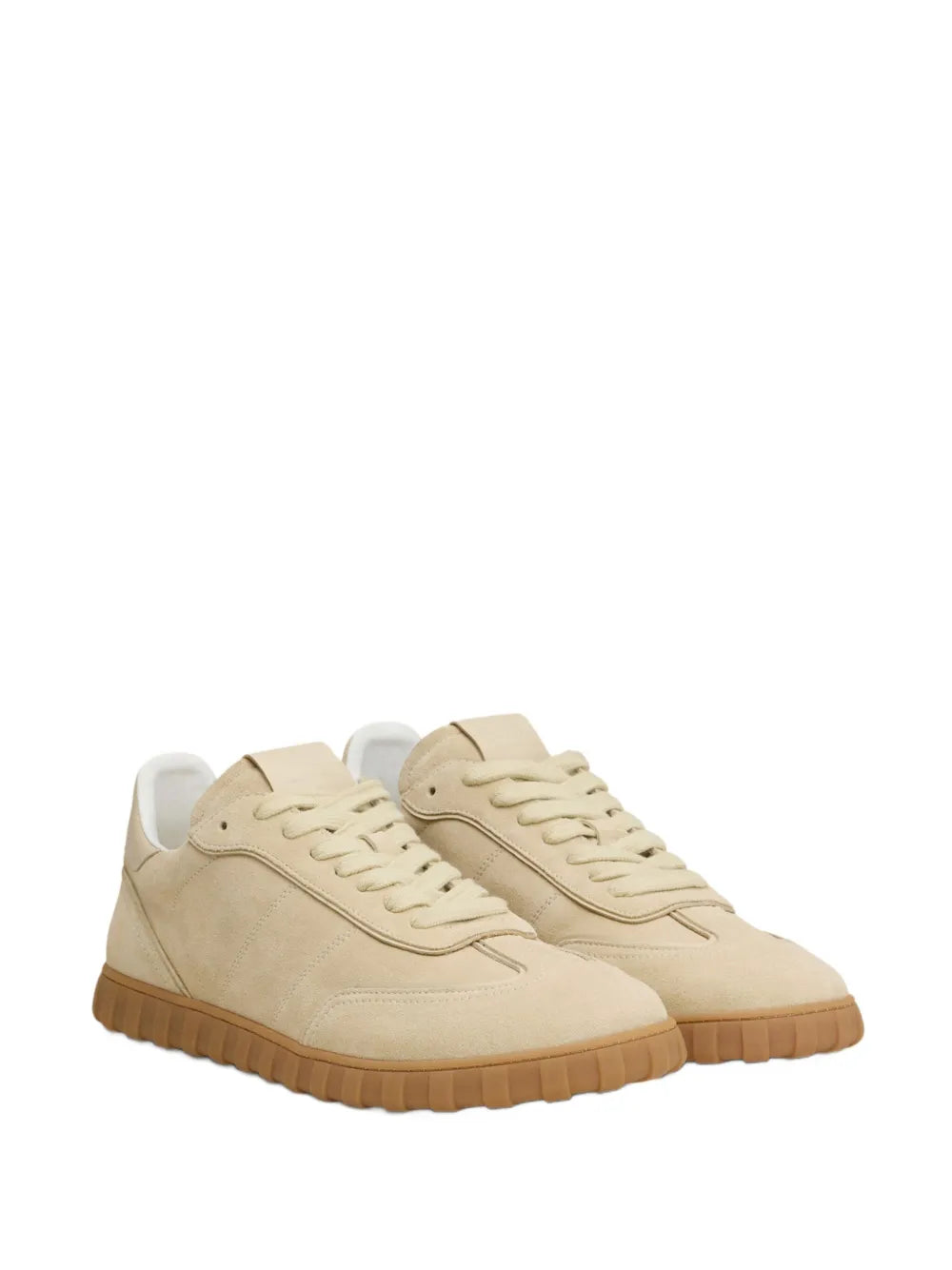 Pair of light beige lace-up sneakers with textured rubber sole, side view