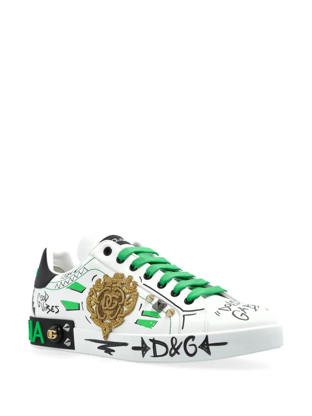White low-top sneakers with green laces, gold crest patch, side graffiti print