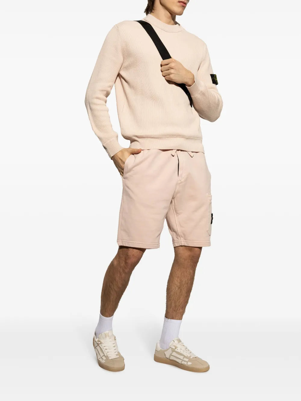 Beige sneakers worn with shorts, lace-up low-top style and gum sole