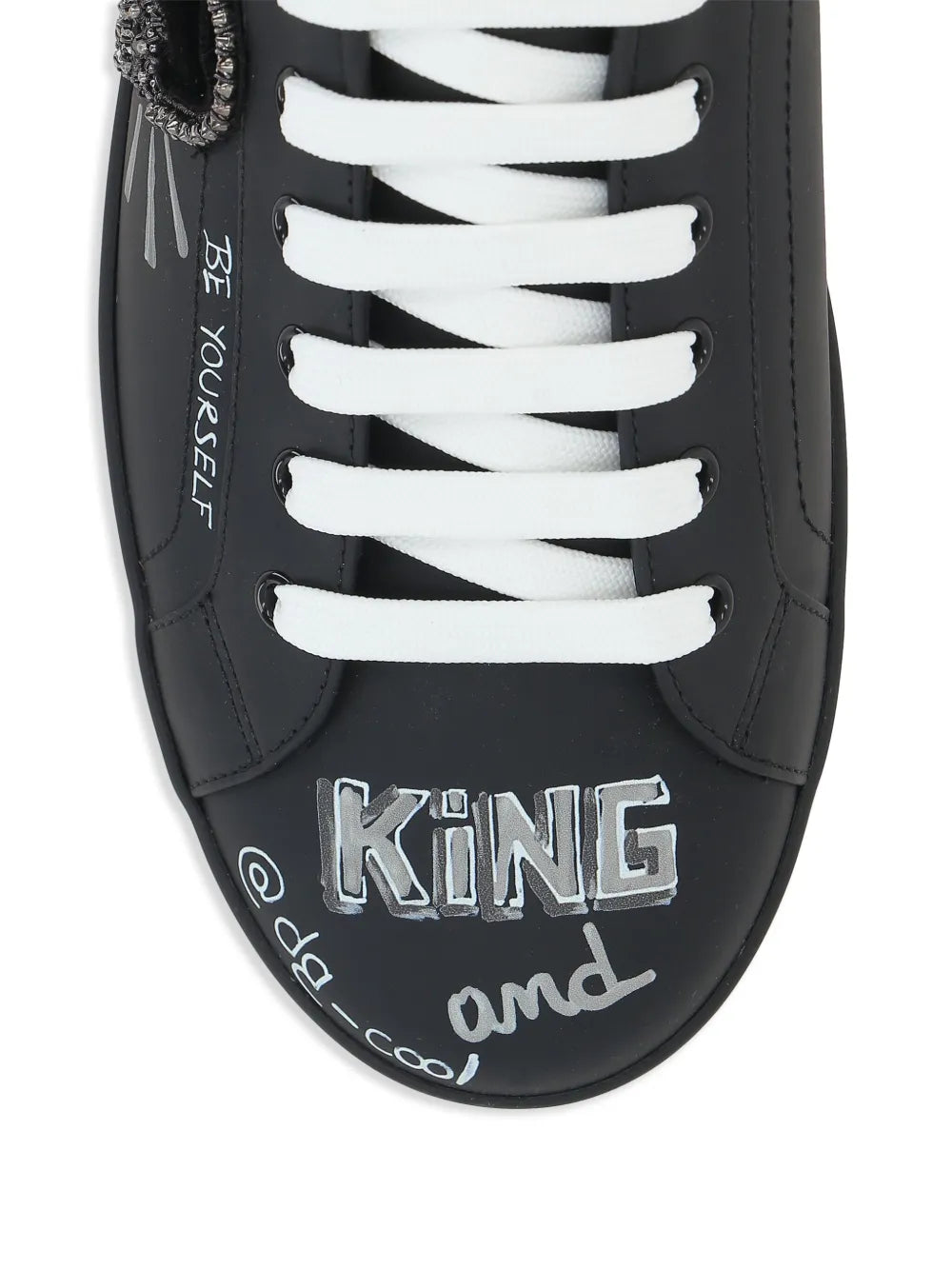 Dolce & Gabbana black sneaker close-up with 'KING' artwork and white lace