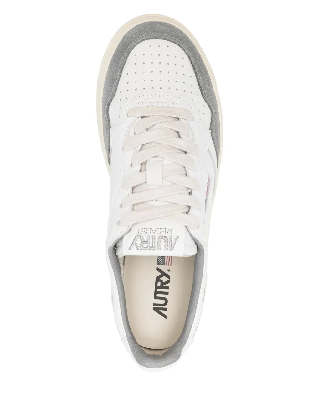 Front view of white low-top sneaker with gray lining, lace-up, perforated toe