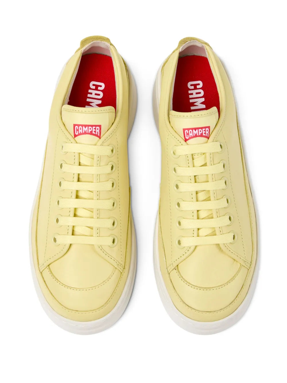 Yellow Camper sneakers with red logo lining, lace-up front, and white sole