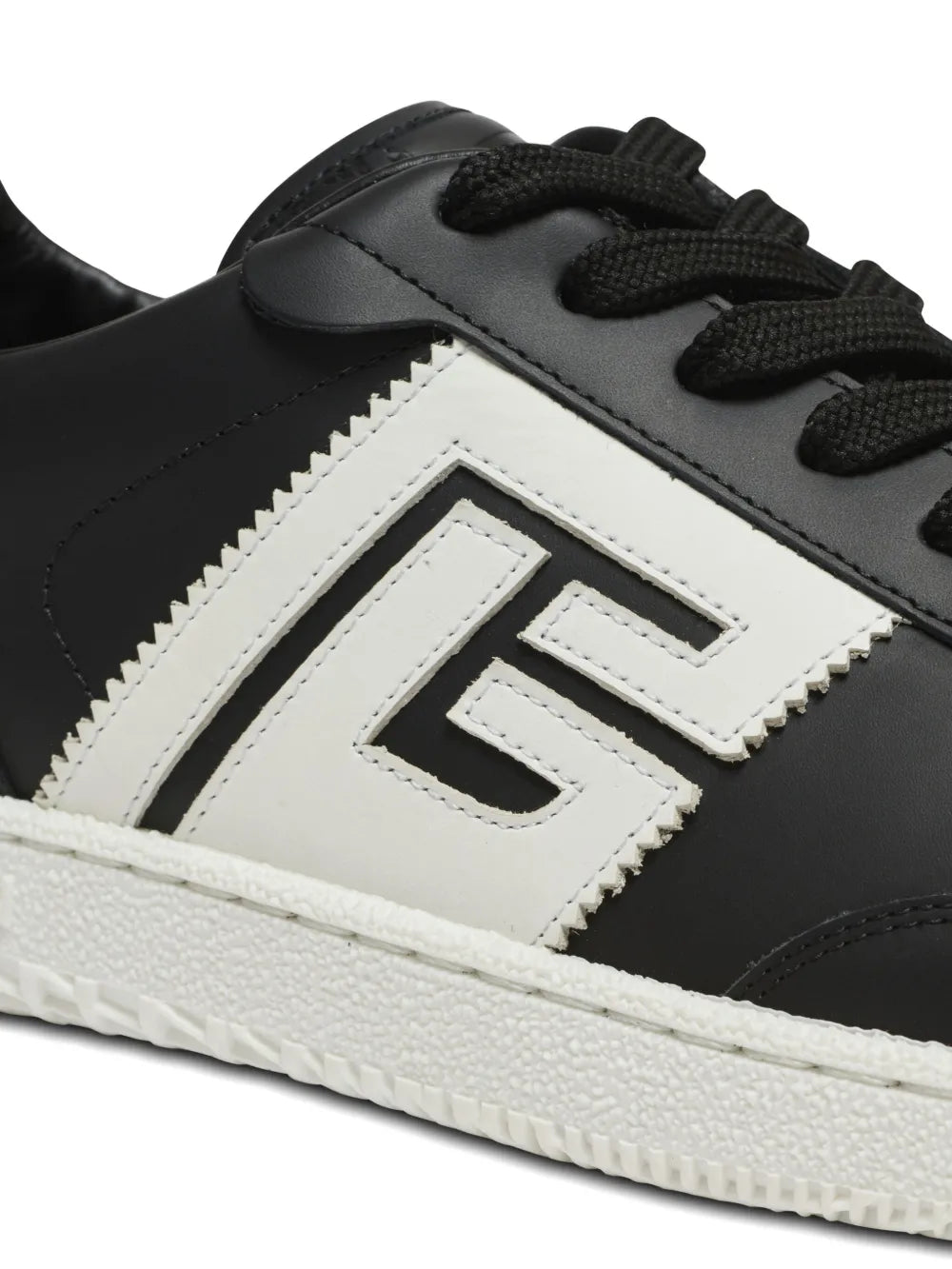 Close-up of black-and-white sneakers with white chevron B logo and black laces