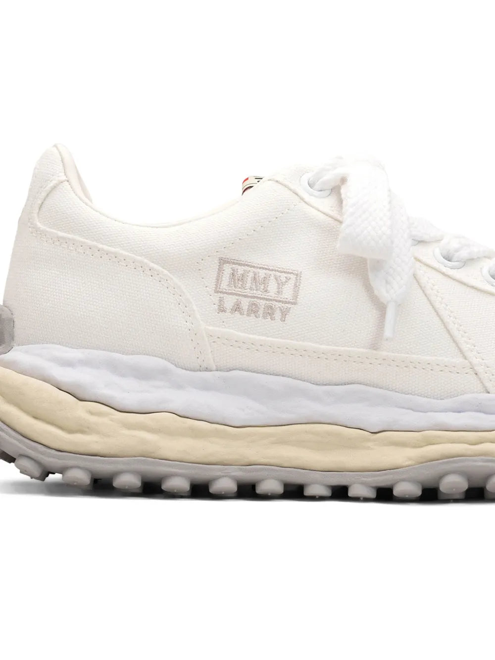 White lace-up sneaker with tongue logo patch and rubber tread sole