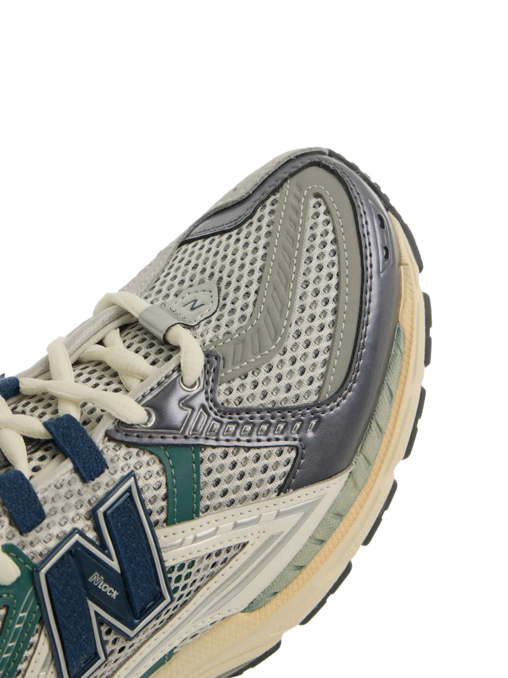 New Balance 1906 sneakers close-up, gray mesh with teal panel and blue logo
