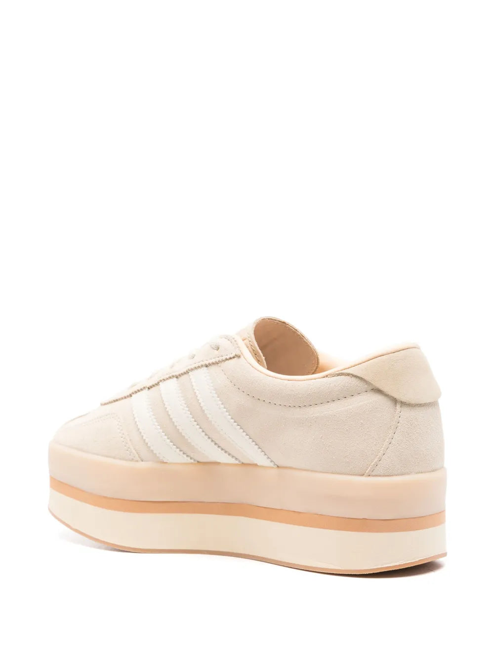 Cream adidas sneakers with rear heel tab, three stripes, and stacked gum platform