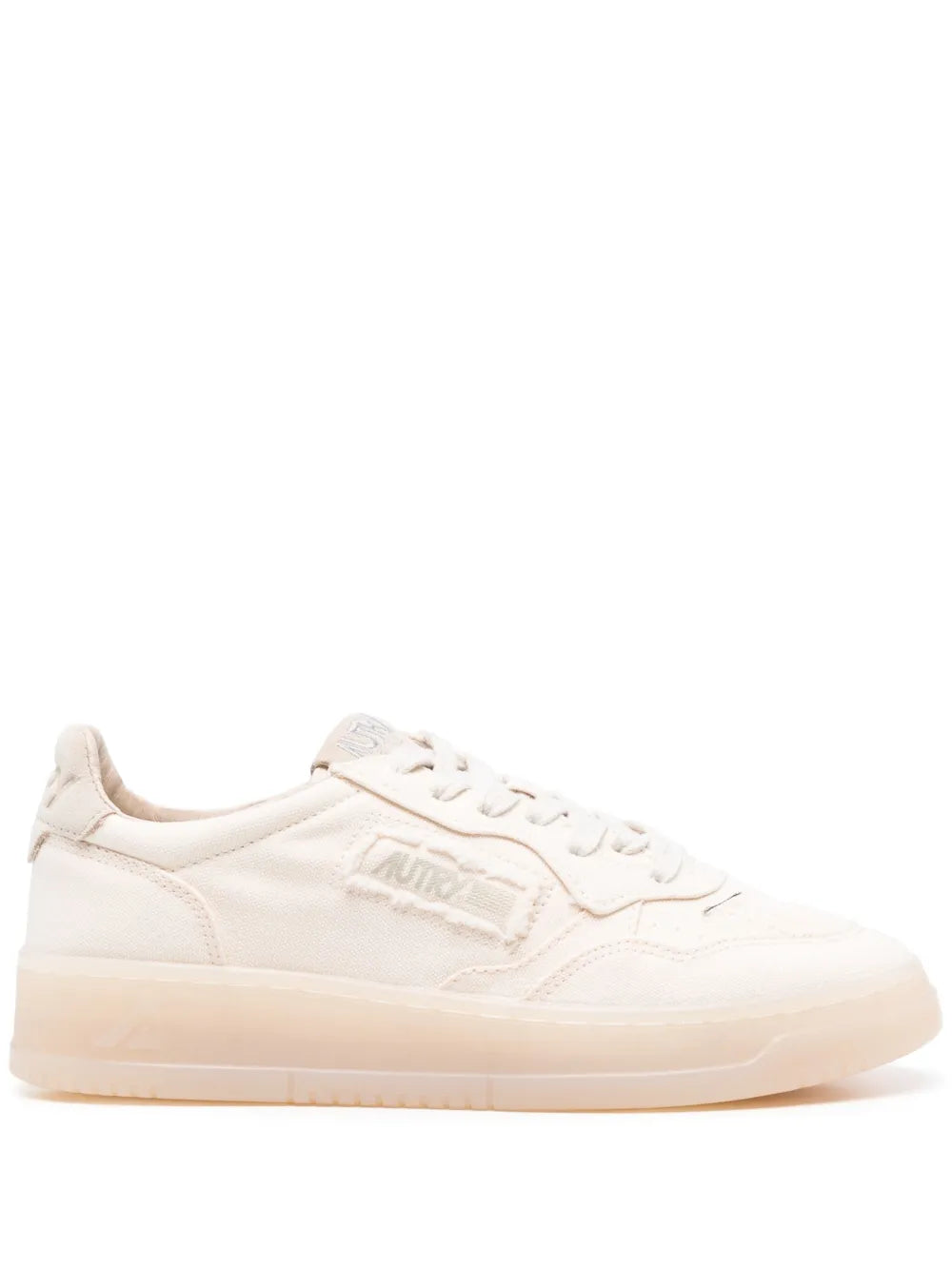 White low-top sneaker with lace-up front, side logo, and gum sole