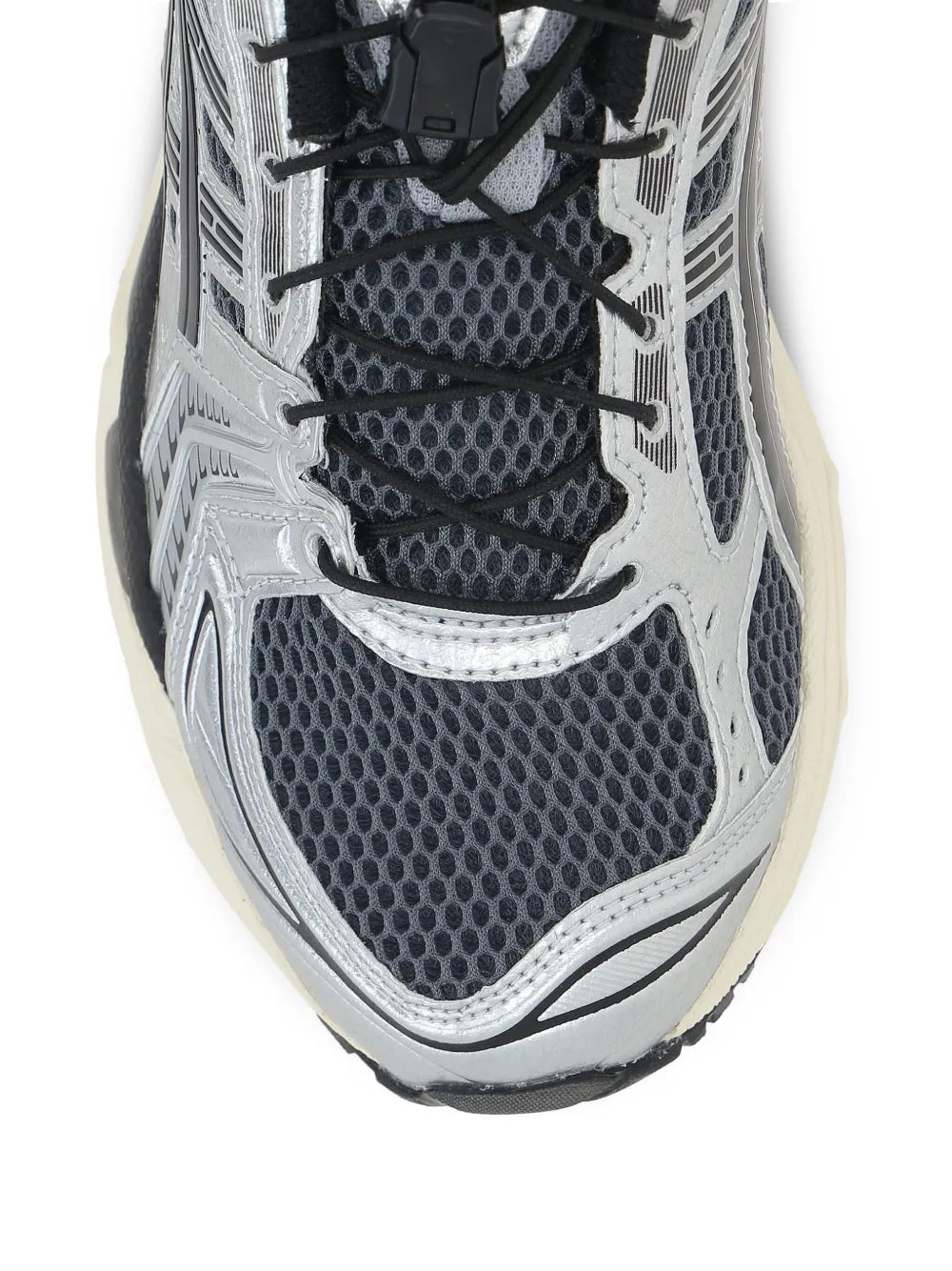 Close-up of grey running shoe upper: black mesh panels and lace eyelets