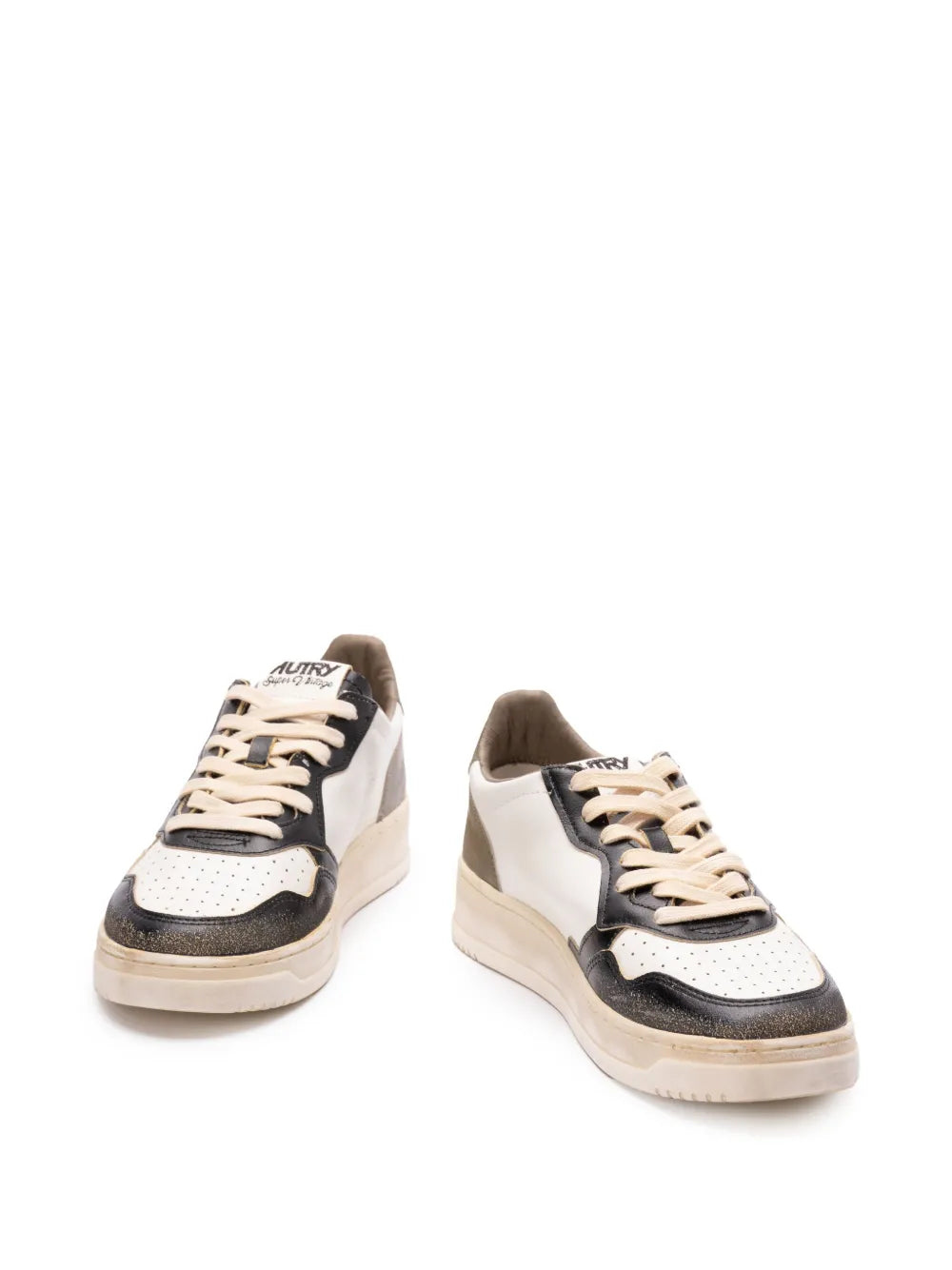 Low-top sneakers in white, black, and tan with lace-up front and panel detailing.