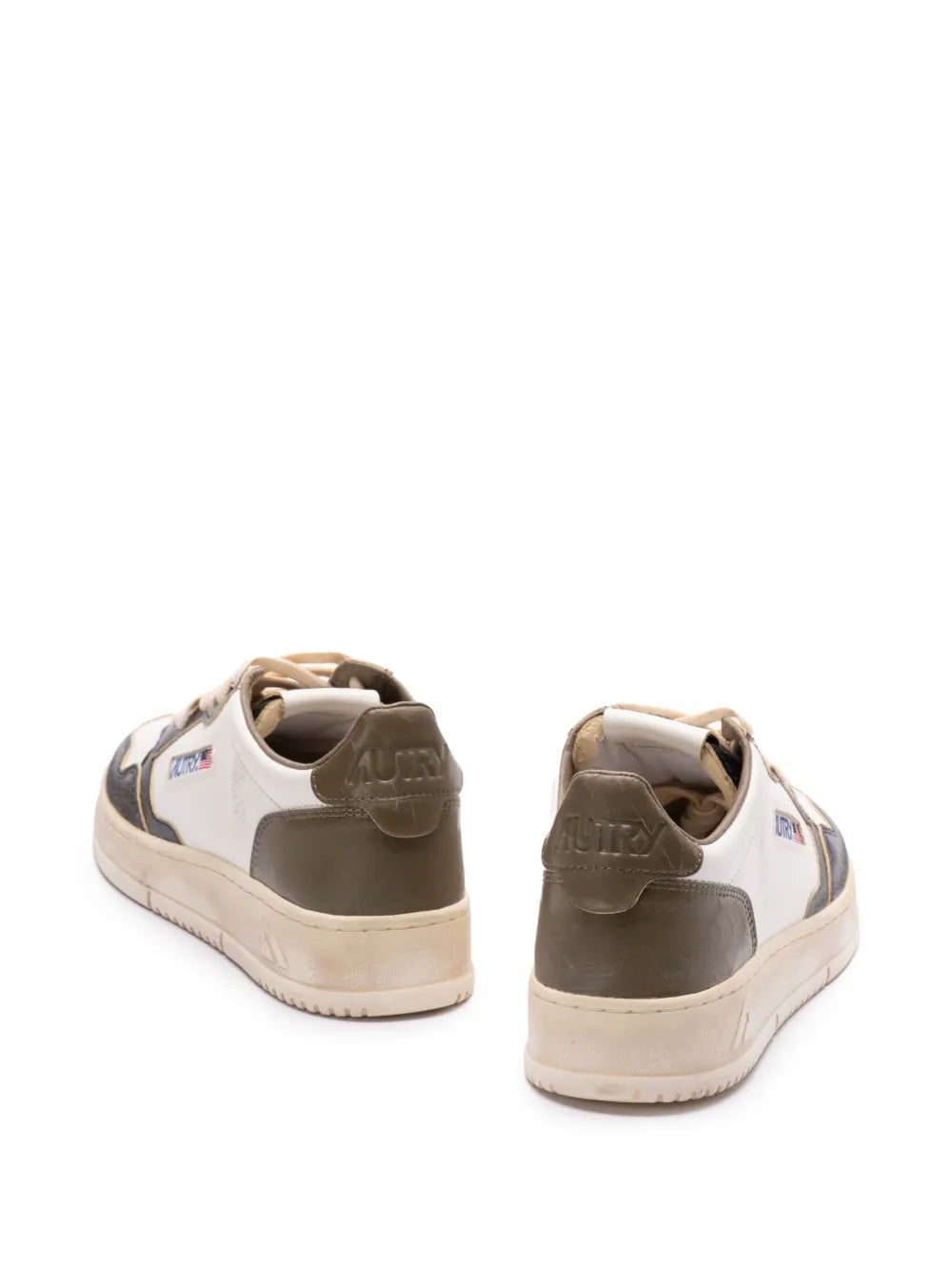 Back view low-top sneakers in white and black with padded collar and beige sole.
