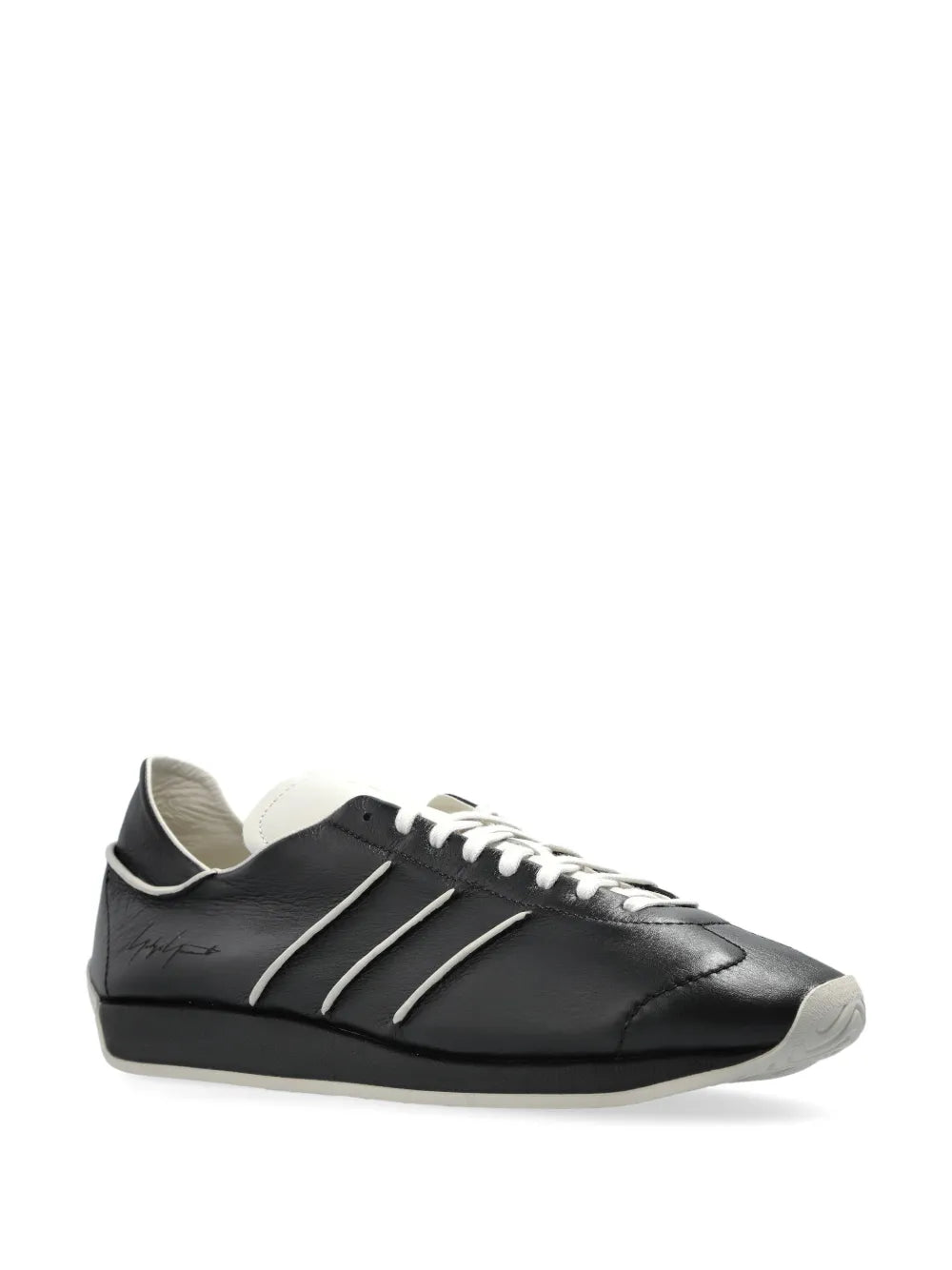 Black low-top sneakers with white lace-up panel and three-bar stripes