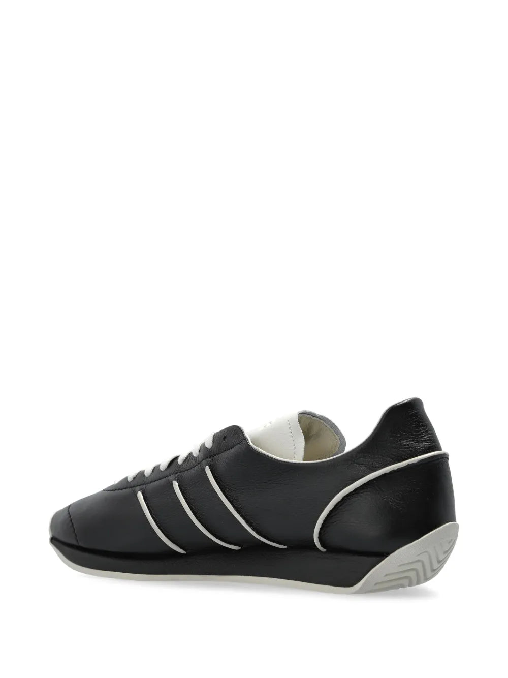 Black low-top sneakers with white side stripes and rounded toe