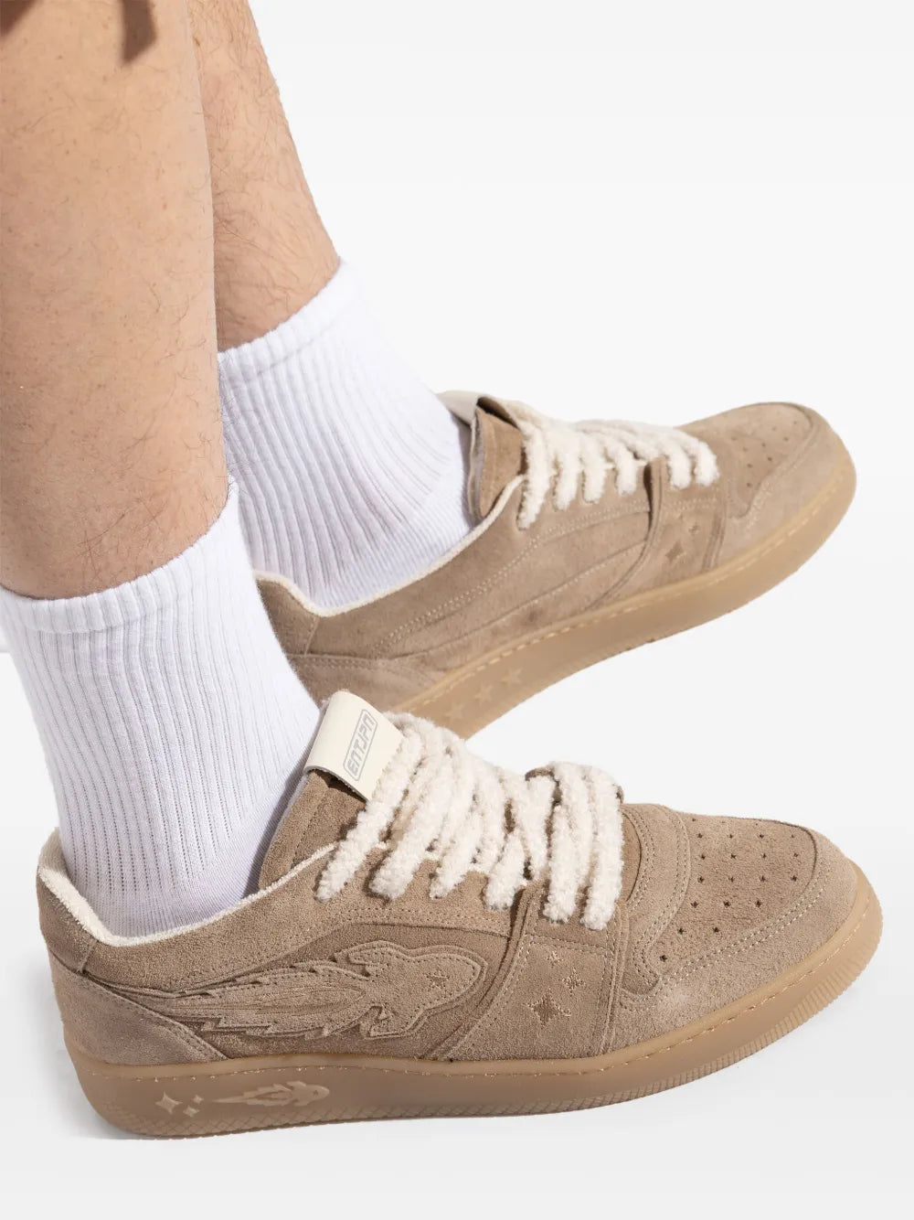 Light brown suede sneakers with white crew socks and lace-up front