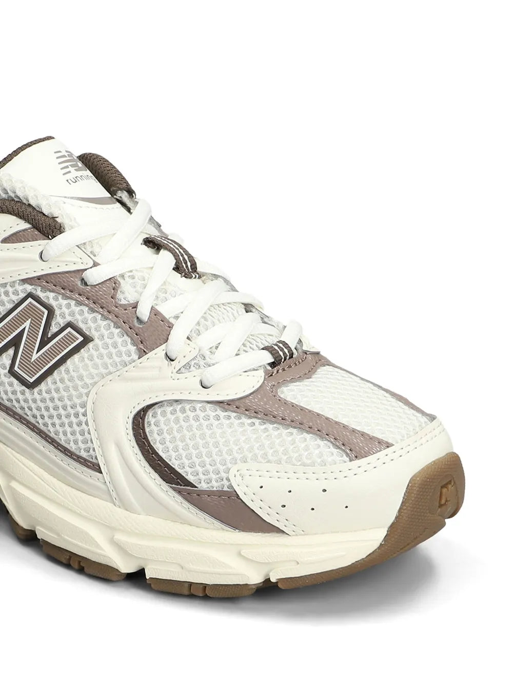 White New Balance 530 sneaker upper close-up with laces, N logo, textured panels