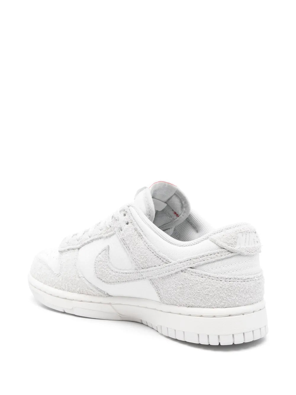 White Nike Dunk Low low-top sneakers, rear side view, lace-up suede upper