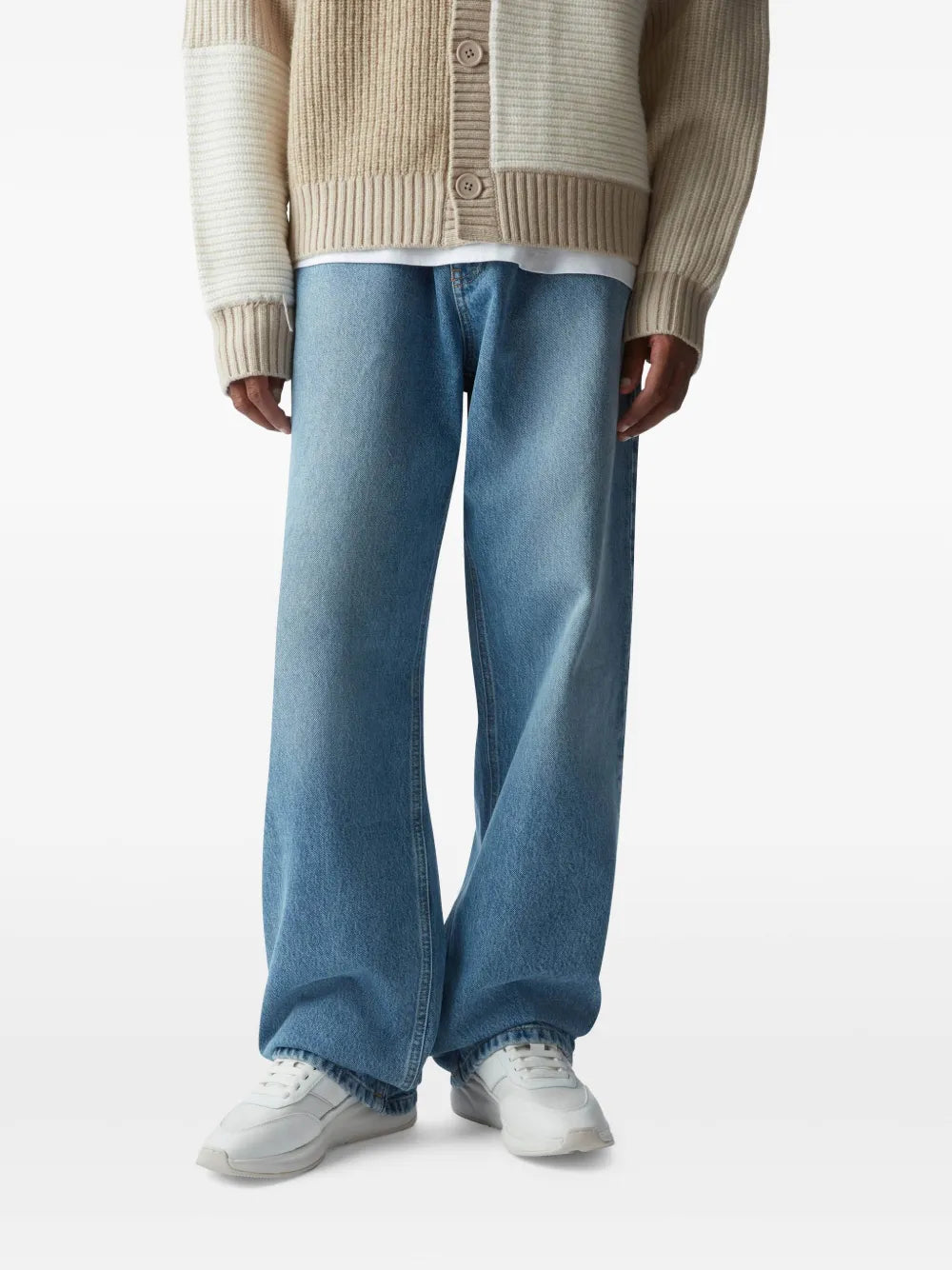 White sneakers worn with light-blue wide-leg jeans