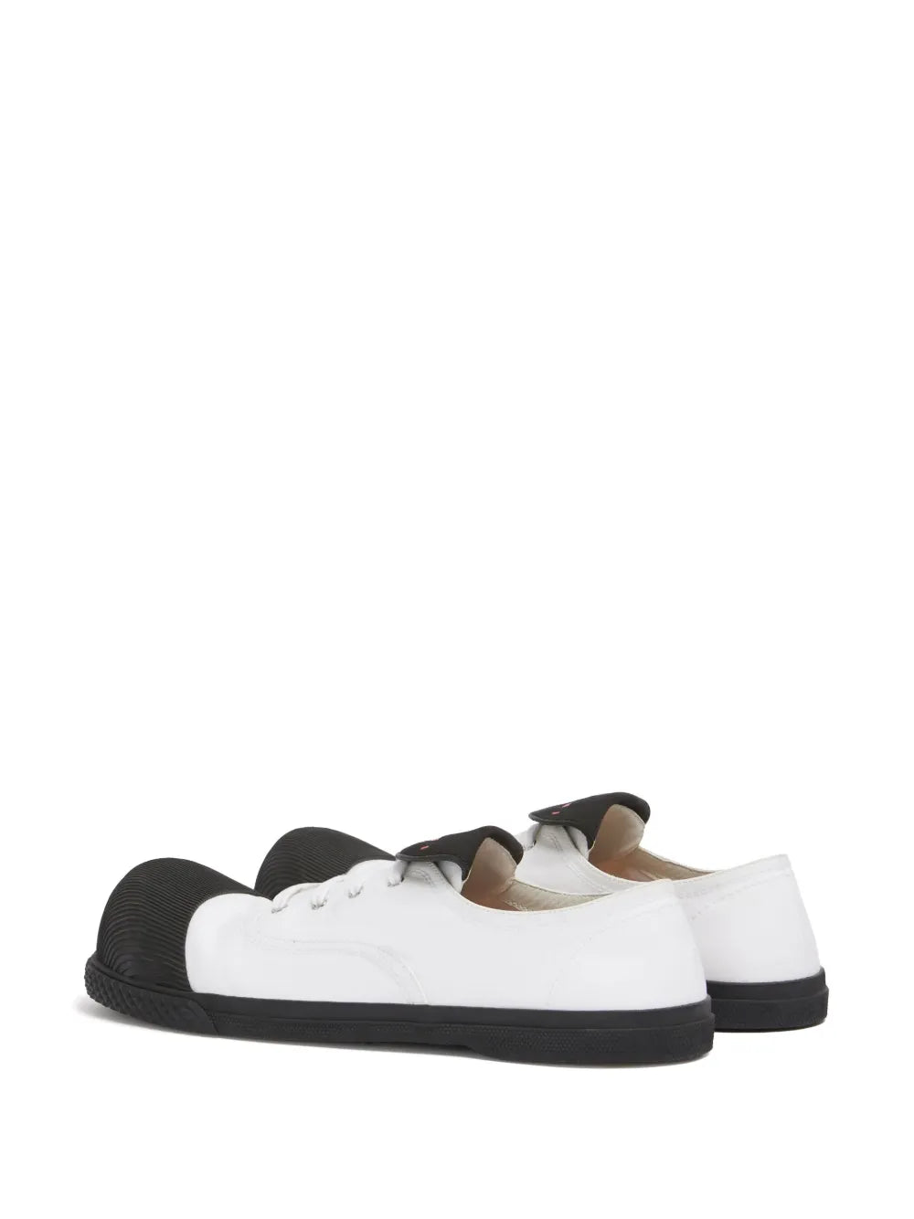 White low-top sneakers with black textured soles and lace-up front