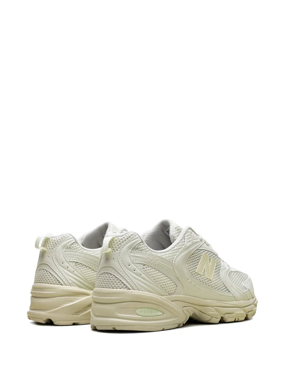 White low-top sneaker side view with gold N logo and sculpted beige midsole