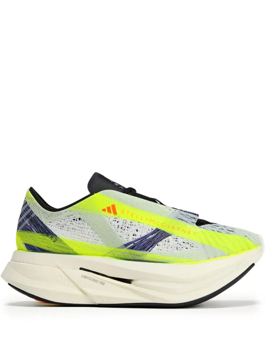 Neon green and white running shoes with black heel, knit upper, thick sole.