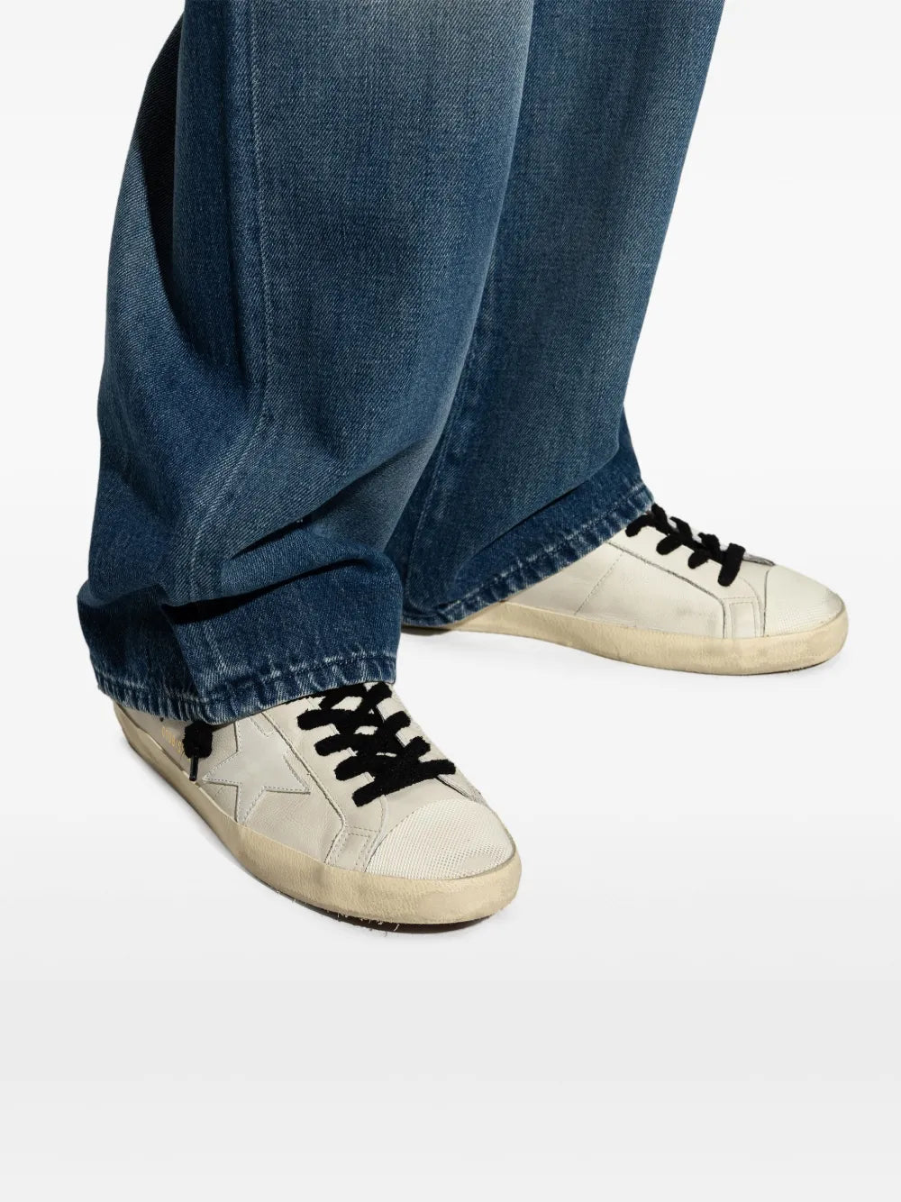 Golden Goose Super-Star sneakers close-up, white leather with star panel and black lace-up