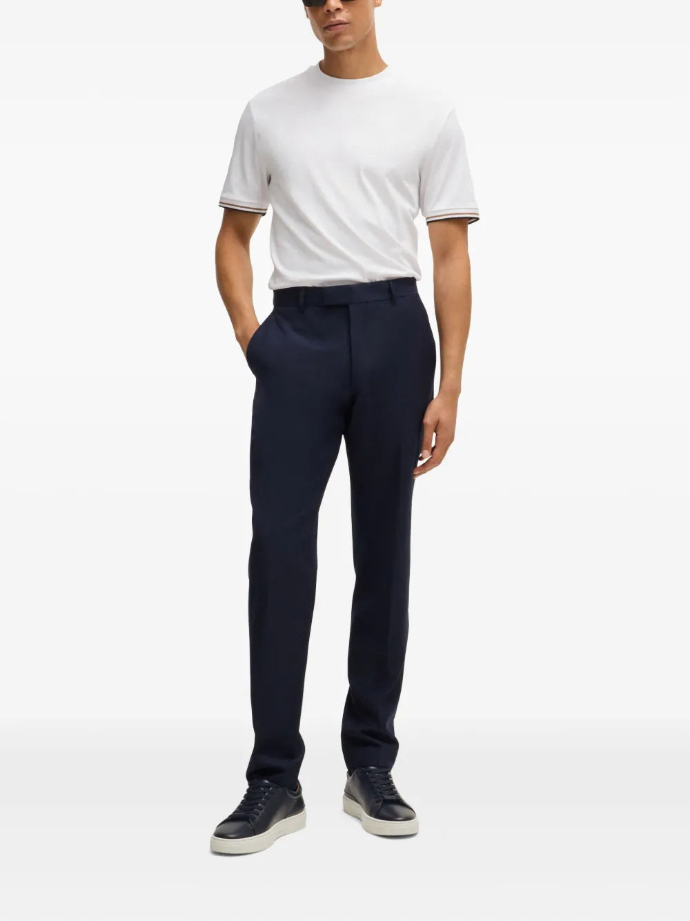 Navy leather lace-up sneakers with white sole, worn with dark trousers