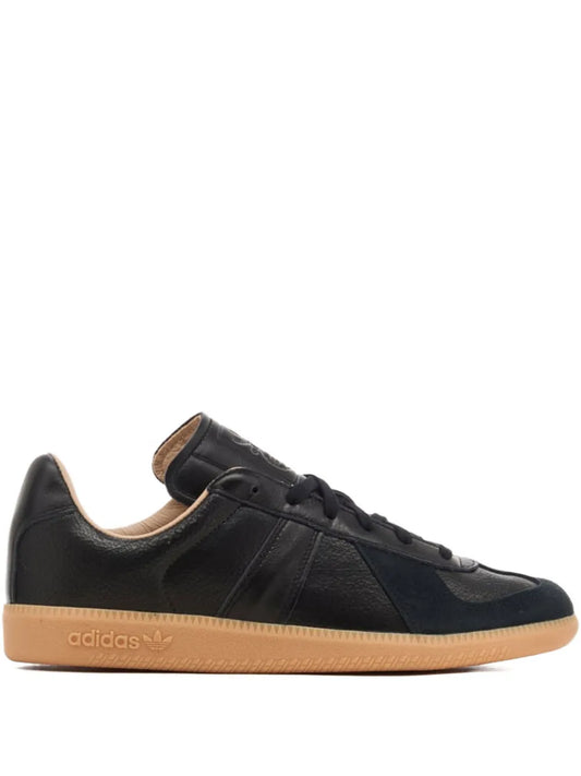 adidas low-top sneaker in black leather with tan gum sole and lace-up front