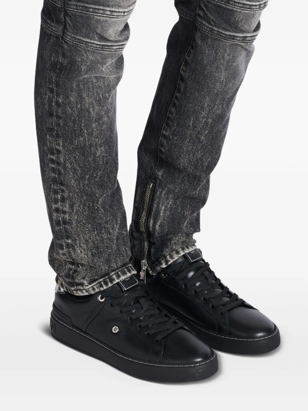Balmain B-Court sneakers on model, black leather lace-up with low-profile rubber sole