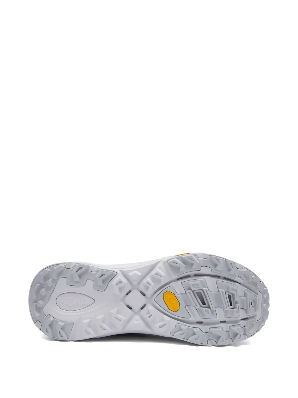 Hoka sneaker outsole with rugged tread pattern and yellow traction mark
