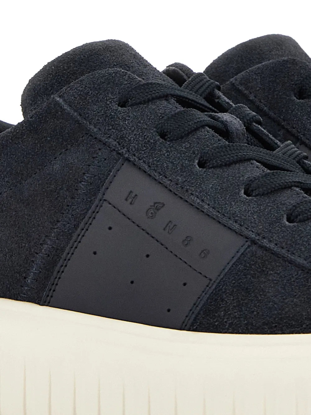 Midnight blue sneaker upper close-up with suede texture, H-stripe panel, black laces